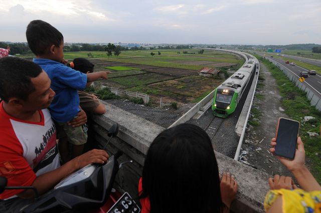 Warga melihat kereta api Bandara Adi Soemarmo melintas di jalur kereta api Stasiun Balapan Solo - Stasiun Bandara Adi Soemarmo. Foto: ANTARA FOTO/Mohammad Ayudha