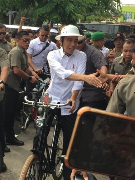 Presiden Jokowi menyapa warga saat gowes ke Kota Lama Semarang.  Foto: Afiati Tsalitsati/Kumparan