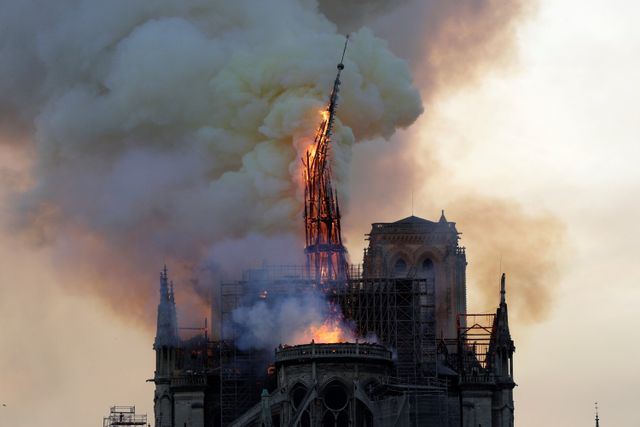 Menara dan puncak menara Katedral Notre-Dame yang terbakar api di Paris, Prancis pada 15 April 2019. Foto: AFP/Geoffroy VAN DER HASSELT