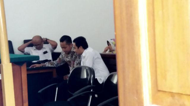 Irfan Nuralam berbincang dengan kuasa hukumnya saat menghadiri sidang pembacaan putusan. (Rd Algifari Suargi)