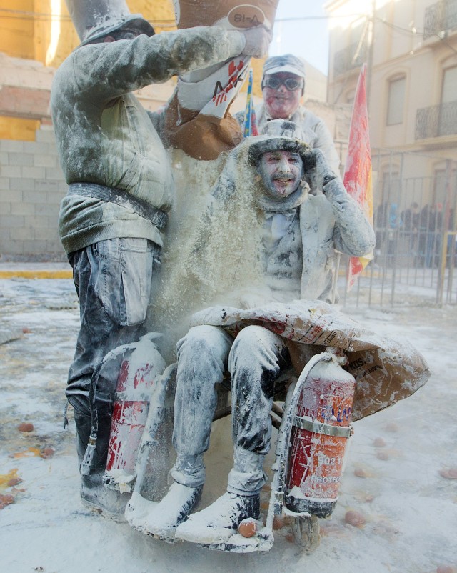 Peserta menuangkan tepung ke peserta lain saat Festival Els Enfarinats di kota Ibi, Spanyol. Foto: AFP/JAIME REINA