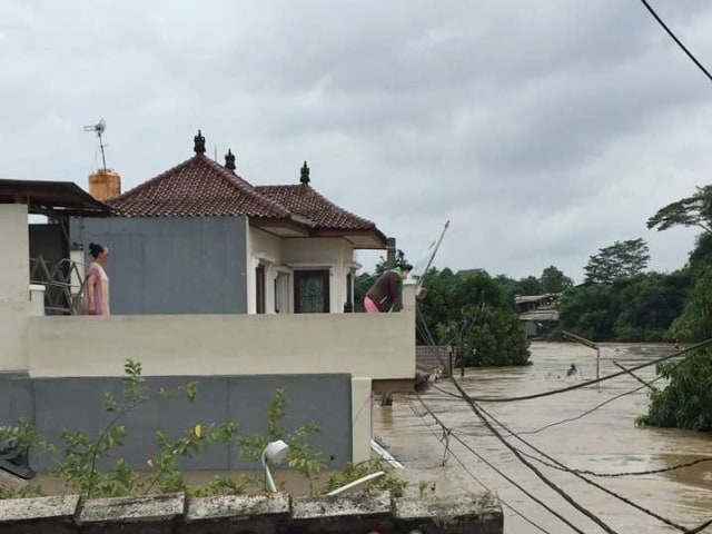 Warga melihat banjir dari lantai dua rumah mereka saat banjir merendam di Villa Nusa Indah, Bekasi, Rabu (1/1). Foto: Dok. Maeli