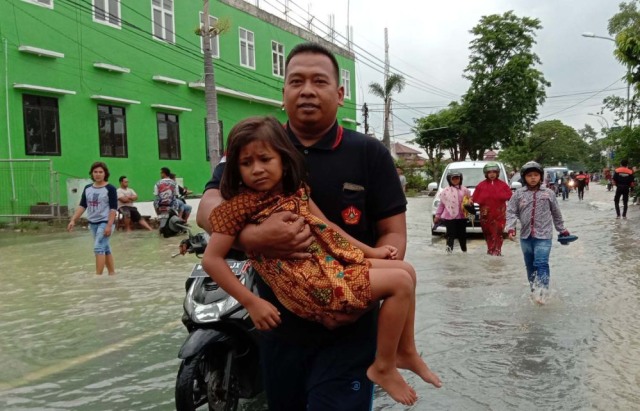 Melihat Banser Bantu Pengendara Motor yang Terjebak Banjir di Gresik