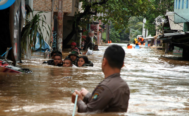 Personel Brimob Polri dan TNI mengevakuasi warga yang terjebak banjir di kawasan permukiman Cipinang Melayu, Jakarta, Rabu (1/1). Foto: ANTARA FOTO/Risky Andrianto