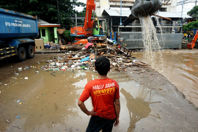 Petugas Pintu Air Manggarai saat membersihkan sampah di aliran sungai. Foto: Nugroho Sejati/kumparan