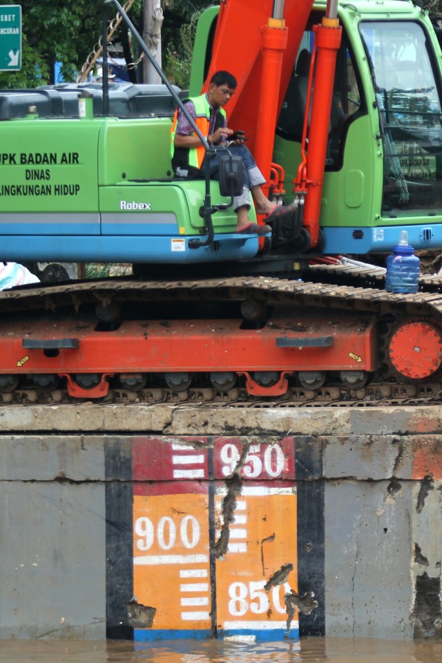 Petugas Pintu Air Manggarai saat membersihkan sampah di aliran sungai. Foto: Nugroho Sejati/kumparan