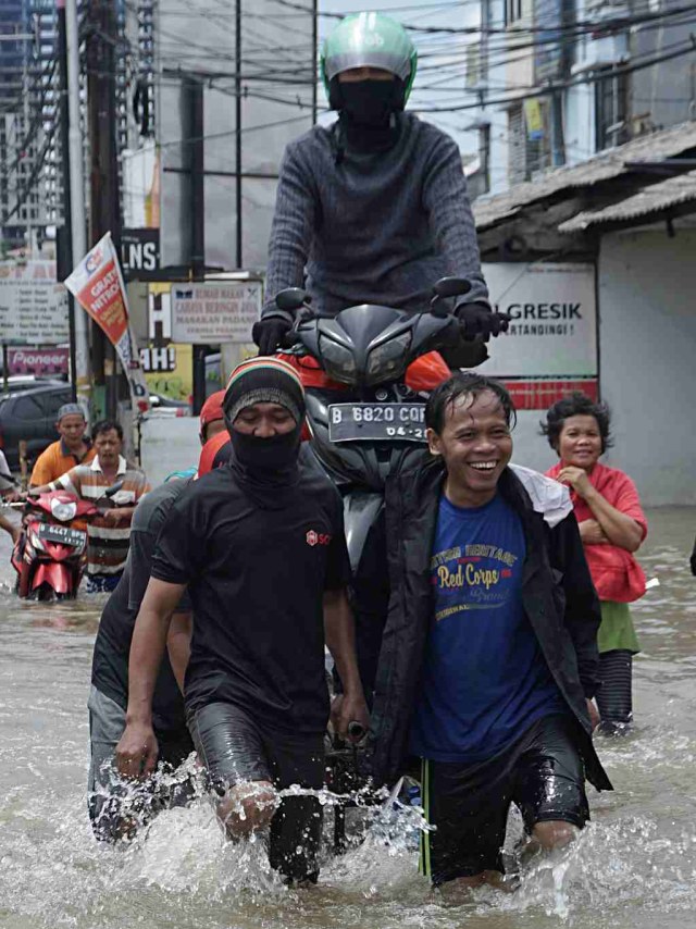 Warga menggunakan jasa angkut gerobak untuk melintasi jalan yang terkena banjir di kawasan Ciledug Indah, Tangerang, Kamis (2/1). Foto: Fanny Kusumawardhani/kumparan