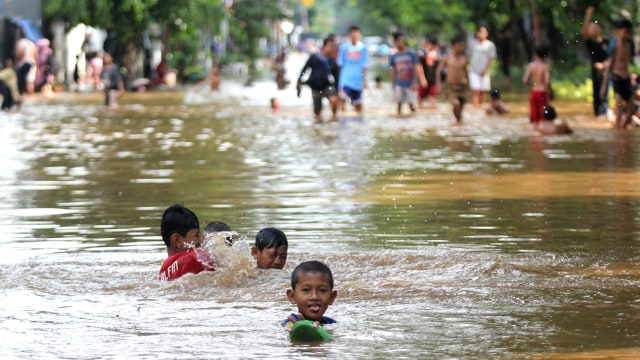 Sejumlah anak bermain saat banjir terjadi di Bungur Raya, Jakarta Pusat, Kamis (2/1).  Foto: Nugroho Sejati/kumparan 