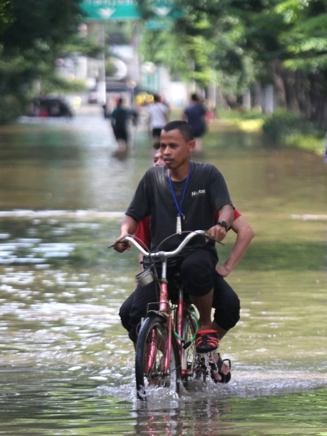 Warga menggunakan sepeda melintas saat banjir terjadi di Bungur Raya, Jakarta Pusat, Kamis (2/1).  Foto: Nugroho Sejati/kumparan 