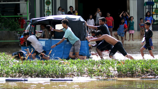 Warga mendorong Bajaj yang yang melintas banjir di Jalan Bungur Raya, Jakarta Pusat, Kamis (2/1).
 Foto: Nugroho Sejati/kumparan 