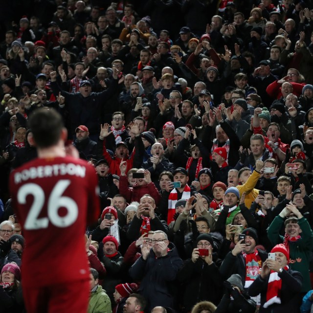 Andy Robertson memberi salam pada suporter Liverpool di Anfield. Foto: Reuters/Carl Recine