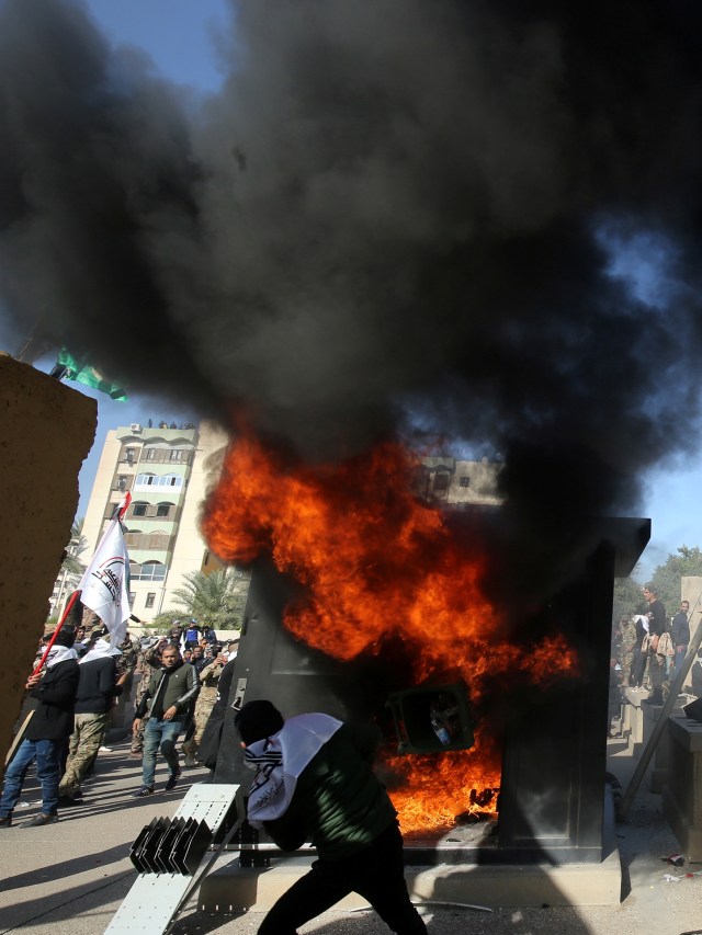 Demonstran di Irak membakar pos penjagaan di kantor kedutaan besar AS di ibukota Baghdad. Foto: AFP/AHMAD AL-RUBAYE