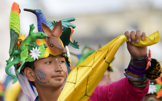Seorang yang bersuka ria ikut serta dalam parade "Canto a la Tierra" selama Karnaval Orang Kulit Hitam dan Putih di Pasto, Kolombia. Foto: Raul ARBOLEDA / AFP