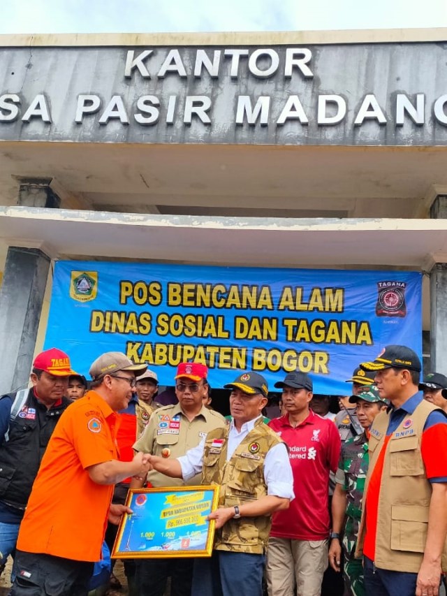 Kepala BNPB Doni Monardo dan Menko PMK Muhadjir Effendy memberikan bantuan dana kepada korban bencana lonsgor di Sukajaya, Kabupaten Bogor. Foto: Dok. BNPB 