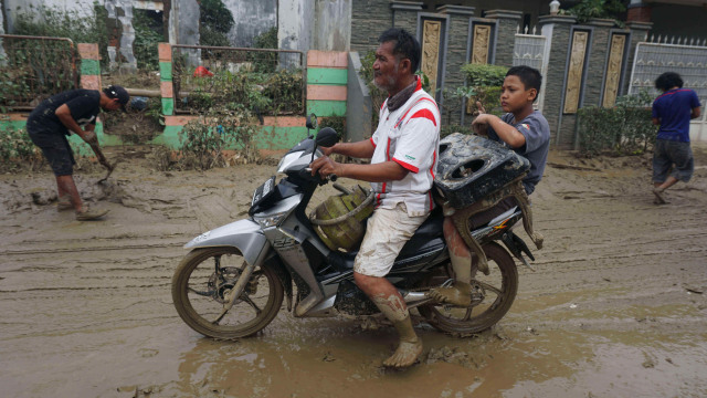 Warga membawa barangdengan motor setelah banjir di kawasan Perumahan Pondok Gede Permai, Jatiasih, Bekasi. Foto:  Irfan Adi Saputra/kumparan