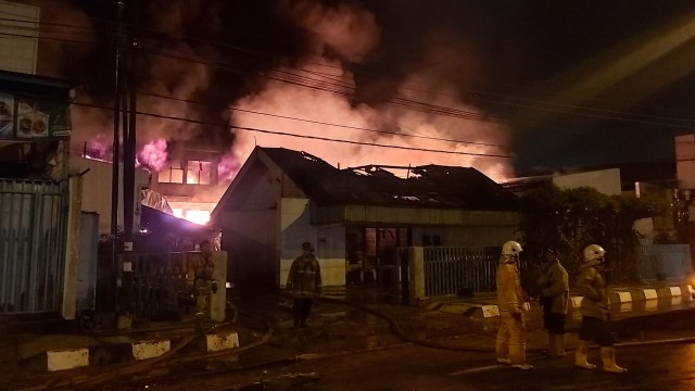 Petuga pemadam kebakaran berusaha memadamkan api kebakaran pabrik lilin di Jalan Jendral Sudirman, Semarang Barat, Kota Semarang, Minggu (5/1).  Foto: Afiati Tsalitsati/kumparan 