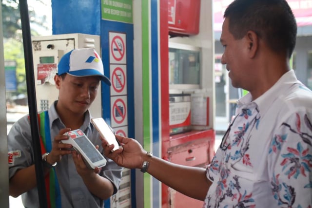 com-Salah satu pelanggan melakukan transaksi pembayaran BBM menggunakan aplikasi MyPertamina di SPBU COCO 31.129.02 Kuningan, Jakarta Foto: Dok. Pertamina