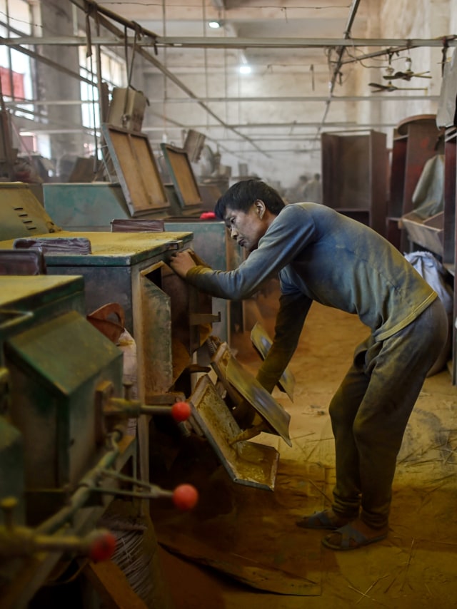 Pekerja sedang mempersiapkan mesin untuk membuat dupa di Pabrik Dupa Fujian Xingquan, Kota Quanzhou di Provinsi Fujian, China. Foto: AFP/HECTOR RETAMAL