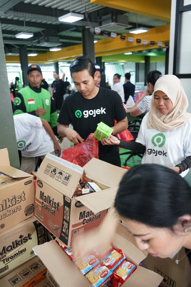 Mitra dan karyawan Gojek memberikan paket bantuan kepada korban bencana banjir Jakarta dan sekitarnya. Foto: Dok. Gojek