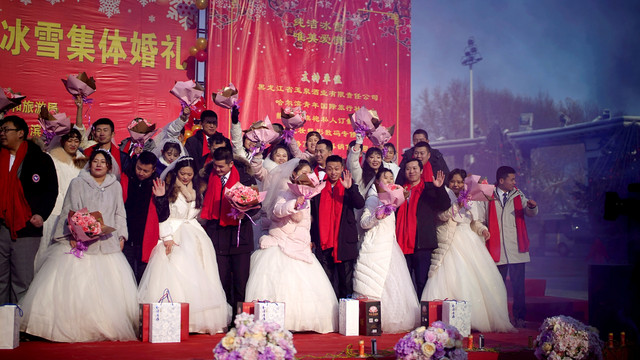 Pasangan pengantin baru merayakan upacara pernikahan massal pada festival es tahunan di kota utara Harbin, provinsi Heilongjiang, China, Minggu (5/1). Foto: REUTERS/Aly Song