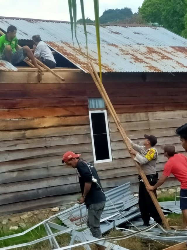 Warga bersama kepolisian bergotong royong membantu memperbaiki rumah milik warga yang rusak akibat diterjang angin kencang. Foto: Lukman Budianto/kendarinesia