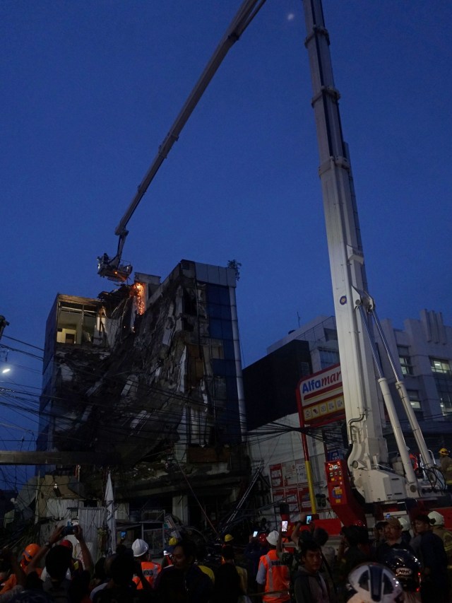 Petugas berusaha memotong beton bagian atas gedung yang roboh, di Slipi, Jakarta Barat, Senin (6/1). Foto: Jamal Ramadhan/kumparan