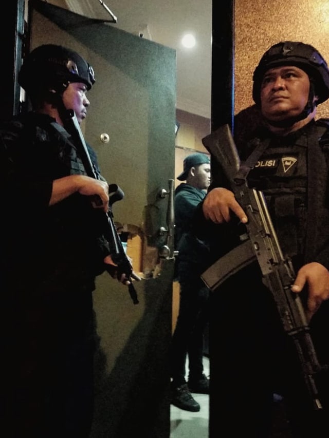 ANGGOTA Brimob Polda Riau bersenjata lengkap saat mengawal penggeledahan tempat hiburan malam Queen Club, Minggu dini hari, 5 Januari 2020. 