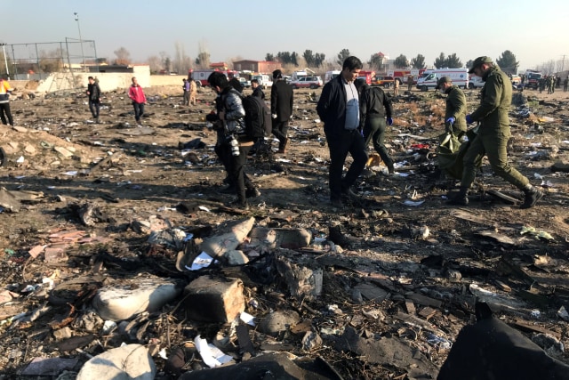 Sejumlah petugas menyisir lokasi jatuhnya pesawat Ukraina International Airlines di Iran.
 Foto: Nazanin Tabatabaee / WANA / via REUTERS