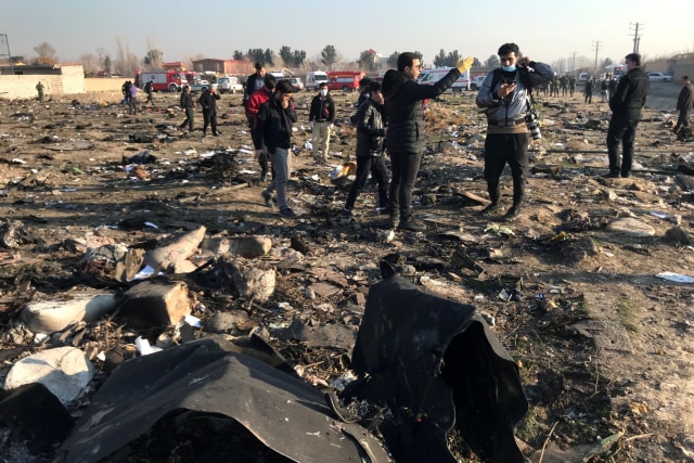Petugas memeriksa barang-barang korban jatuhnya pesawat Ukraina International Airlines di Iran.
 Foto: Nazanin Tabatabaee / WANA / via REUTERS