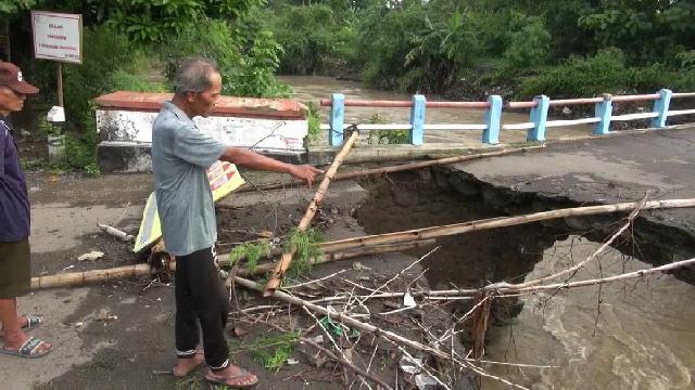 Jembatan penghubung antardesa di Desa Kupu, Kecamatan Dukuhturi, Kabupaten Tegal, putus akibat diterjang arus deras Sungai Kemiri, Rabu (8/1). (Foto: Syaifullah)