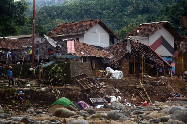 Warga mencari sisa barang di puing reruntuhan rumahnya yang rusak terkena banjir bandang di Kampung Cinyiru, Banjar Irigasi, Lebak, Banten, Kamis (9/1). Foto: ANTARA FOTO/Asep Fathulrahman