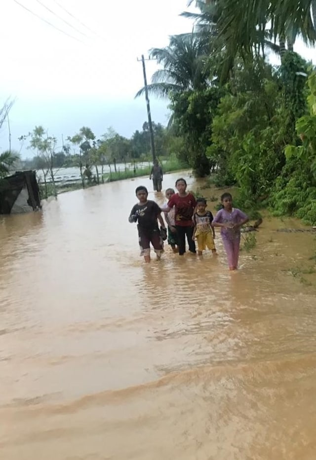 Anak-anak di Kabupaten Aceh Barat Daya berjalan di genangan banjir. Foto: Dok, BPBD Abdya