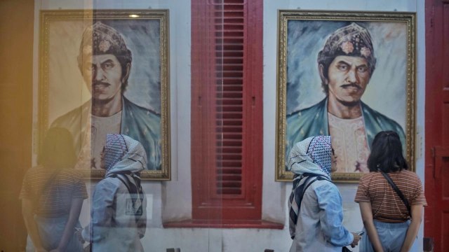 Dua orang pengunjung yang tengah melihat lukisan bergambar Sultan Mahmud Badaruddin II di Muesum Sultan Mahmud Badaruddin II Palembang, Jumat (10/1) Foto: ary priyanto/Urban Id