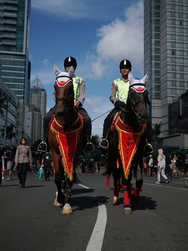 Anggota Dispolsatwa melakukan patroli menggunakan kuda di Car Free Day (CFD) di Bundaran HI, Jakarta, Minggu (12/1).  Foto: Jamal Ramadhan/kumparan 