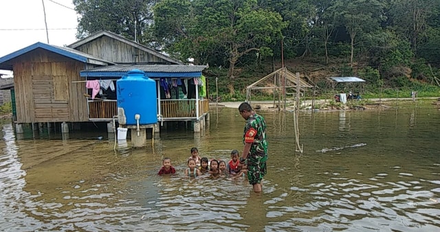﻿﻿Babinsa TNI AD saat melihat warga yang mengalami banjir. Foto: Khairul S/kepripedia.com