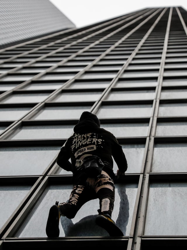 Pendaki Prancis Alain Robert, yang juga dikenal sebagai 'Spiderman' memanjat gedung Tour Total di distrik keuangan dan bisnis La Defense, Paris, Prancis.  Foto: AFP / Thomas SAMSON