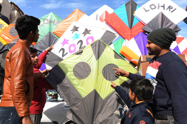 Pelanggan melihat layang-layang yang dipajang di toko layang-layang di Amritsar, (13/1). Foto: NARINDER NANU / AFP