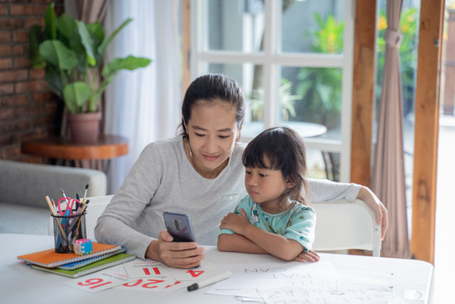 Ilustrasi anak dan ibu menikmati screen time dari ponsel. Foto: Shutterstock