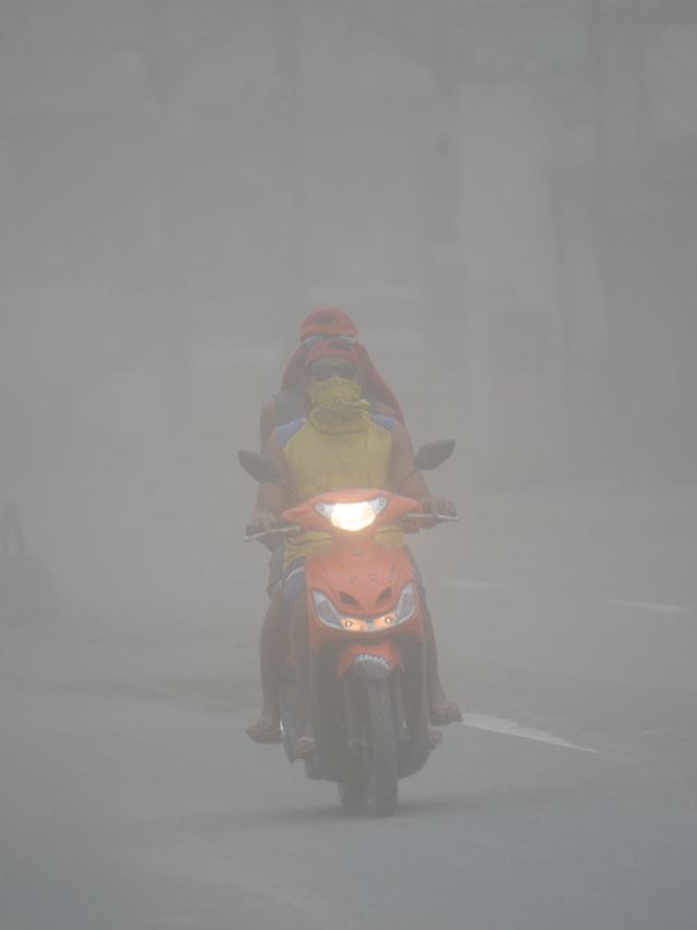 Warga menutupi wajah untuk menghindari abu vulkanik letusan Gunung berapi Taal yang menutupi kota Lemery, Filipina. Foto: AFP/Ted ALJIBE