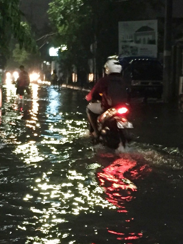 Sejumlah kendaraan melintas banjir di kawasan Wonokromo, Surabaya.
 Foto:  Yuana Fatwalloh/kumparan 