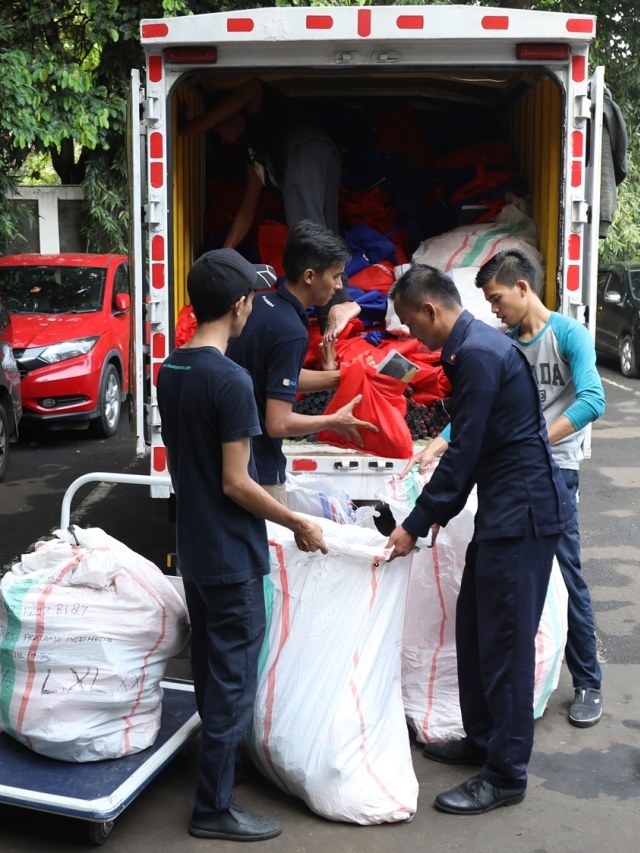 Sejumlah karyawan kumparan memasukkan 1.000 paket untuk korban banjir ke mobil box. Foto: Irfan Adi Saputra/kumparan