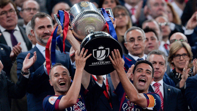 Andres Iniesta dan Xavi Hernandez mengangkat trofi Copa del Rey. Foto: AFP/Josep Lago