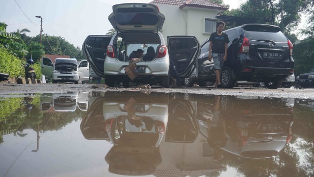 Warga memperbaiki mobilnya yang terendam banjir di Kompleks TVRI Kemandoran VIII, Jakarta Selatan. Foto: Irfan Adi Saputra/kumparan