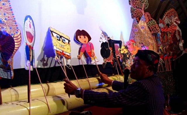 Persatuan Dalang Indonesia Gresik Ki Puguh Prasetyo saat menampilkan wayang Doraemon hingga Spongebob.