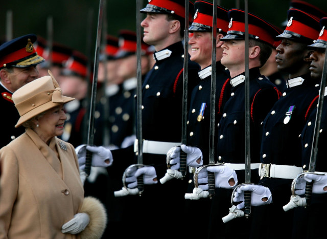 Ratu Inggris Elizabeth II (kiri) tersenyum dengan cucunya Pangeran Harry selama Parade Sovereign di Akademi Militer Kerajaan di Sandhurst, Inggris. Foto: AFP/DYLAN MARTINEZ