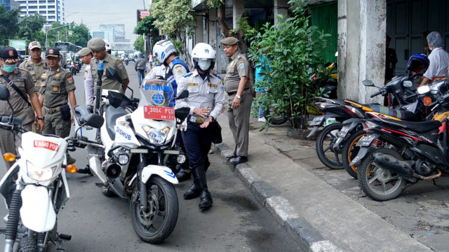 Petugas Dinas Perhubungan DKI Jakarta merazia motor-motor yang parkir liar di kawasan Gajah Mada, Jakarta, Selasa (21/1/2020). Foto: Helmi Afandi/kumparan