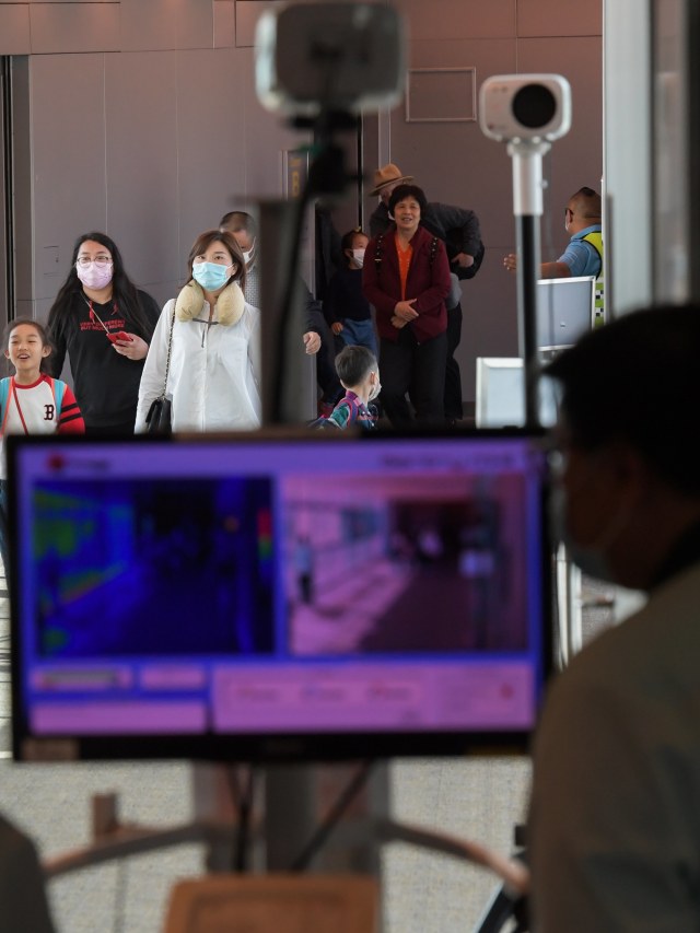 Petugas memindai penumpang untuk mencegah penyebaran virus corona di Bandara Internasional Changi, Singapura. Foto: AFP/ROSLAN RAHMAN