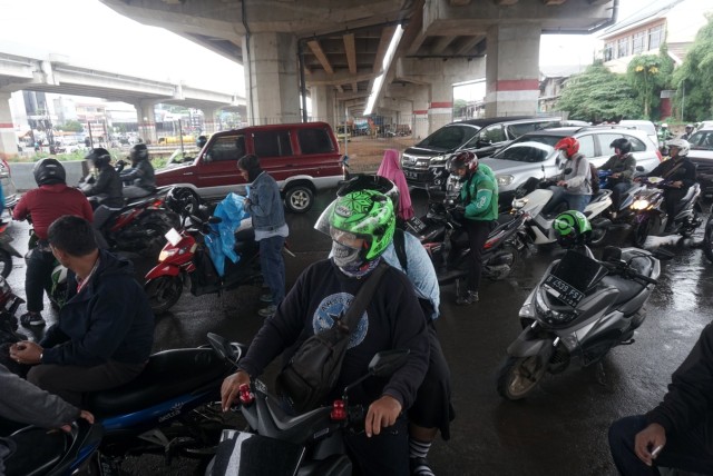 Pemotor berteduh di bawah jalan layang saat hujan deras. Foto: Iqbal Firdaus/kumparan