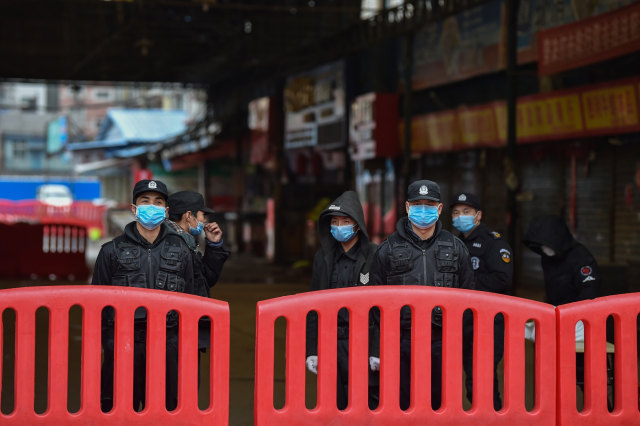 Petugas keamanan berjaga di sekitar Pasar Makanan Laut Huanan lokasi terdeksi Virus Corona di Wuhan, Hubei, China.
 Foto: AFP/HECTOR RETAMAL