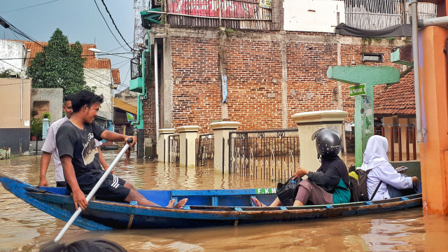 Warga Dayeuhkolot Kabupaten Bandung terpaksa menggunakan perahu untuk alat transportasi karena banjir menggenangi kawasan itu setiap musim hujan. (Foto: Assyifa/bandungkiwari.com)